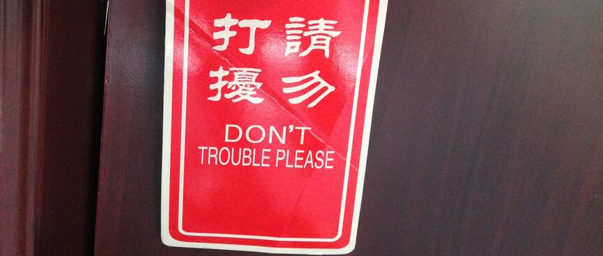 A sign on my door handle reads Donʼt Trouble Please.