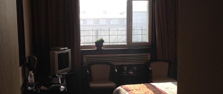 A sunny hotel room with two beds.