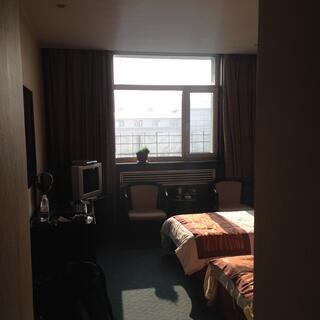A sunny hotel room with two beds.