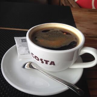 A coffee cup sitting on the edge of a saucer.