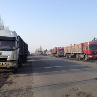 Big trucks line each side of the road.