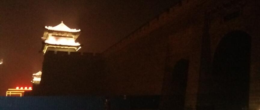 Huge medieval walls with glowing turrets.