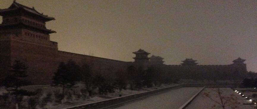 Snow filled moat and tall walls with turrets.
