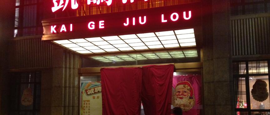 The doorway of the restaurant has neon lighting and a picture of Santa.