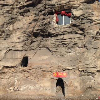 An aluminium framed window high up in a rock wall.