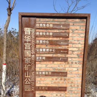 A brick and bronze sign provides directions to the different parts of the mine park.