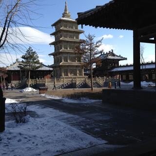 A tower with five levels and a rooftop spike.