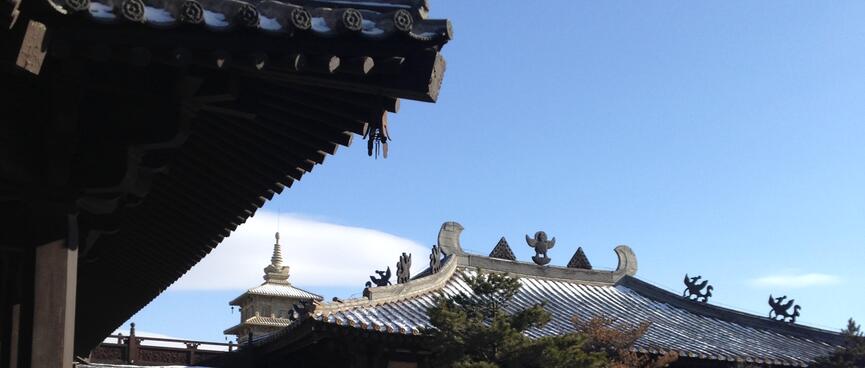 Close-up of roofs and eves with small metal decorations.