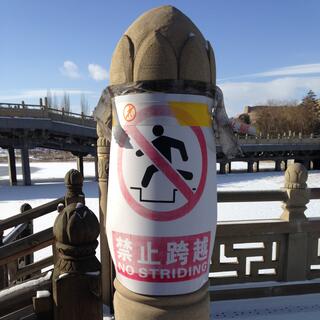 A sign on a wooden post reads ʼNo stridingʼ.