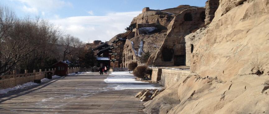 A wide path runs below sandstone cliffs.