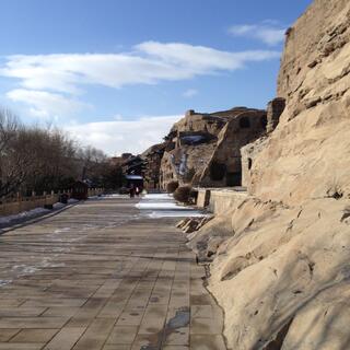 A wide path runs below sandstone cliffs.