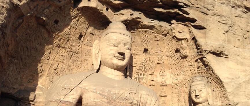 Large and small buddha in a shallow cave.