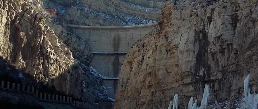 A three tiered wall connects the mountain walls at the end of the valley.