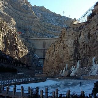 A three tiered wall connects the mountain walls at the end of the valley.