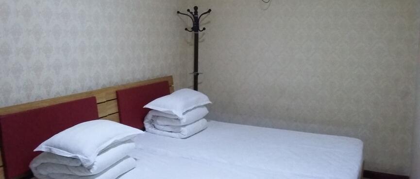 Two single beds are pushed together to create a large double, leaving little space around the outside.