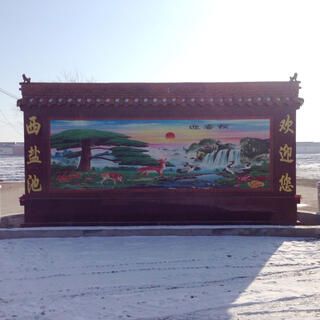 A plaque features a picture of majestic waterfalls, birds, deer and a red sun in a multicoloured pastel sky.