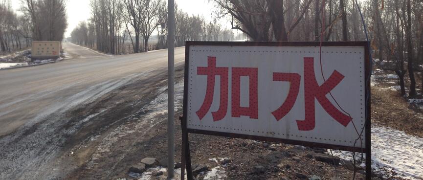 Chinese lettering on a sign at a fork in the road.