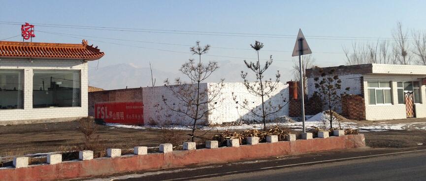 Single story buildings are painted white with red roofs and fences.