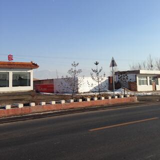 Single story buildings are painted white with red roofs and fences.