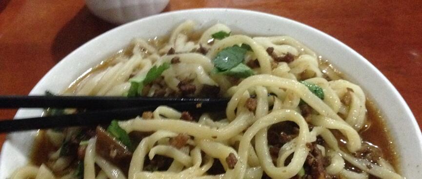 A bowl of noodles and broth.