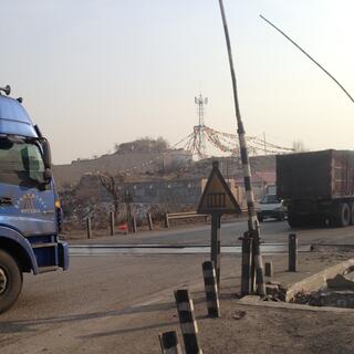 Prayer flags visible in a gap between two trucks.