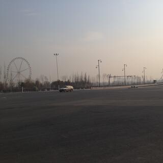 A London-style bridge and a large ferris wheel dominate the flat landscape.