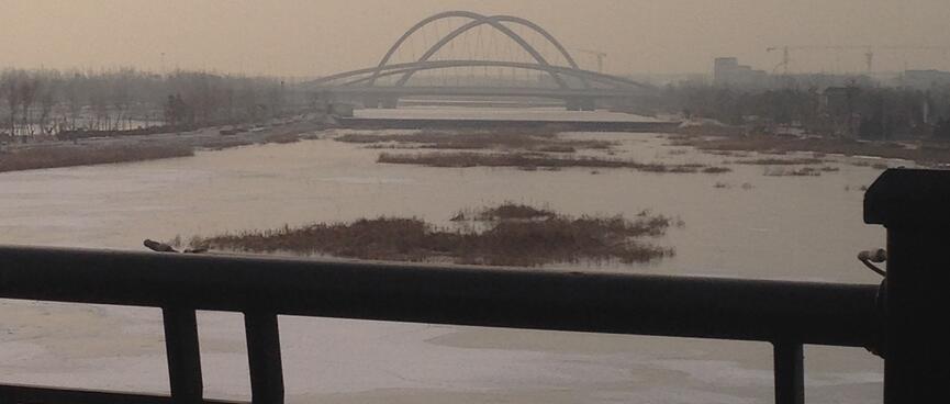 A modern curved bridge as viewed from a more traditional one.