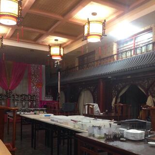 The ceiling of the dining room features ornate round lampshades and a balustrade below internal windows.