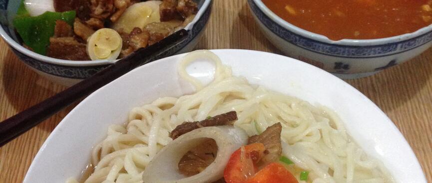 Bowls of meat, vegetables, soup and noodles.