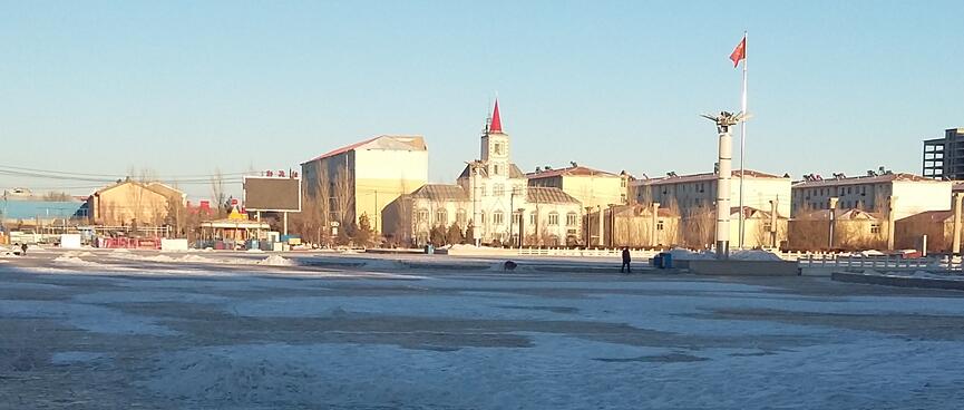 A red turret and flag stand out amongst cream coloured buildings.