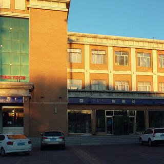 A glass and brick three storey building is illuminated by the sun.