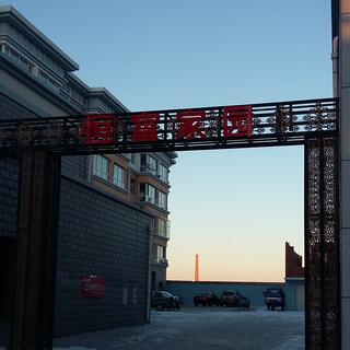 Patterns and red lettering on steel girders forming a gateway.