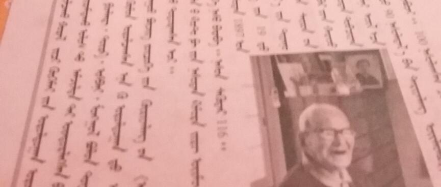 A white page displays black and white photographs and printed columns of vertical script.