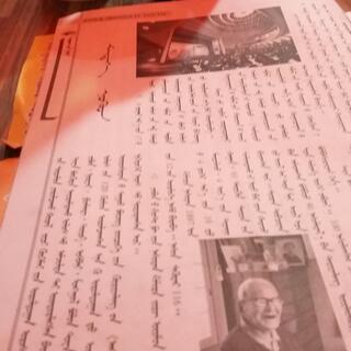 A white page displays black and white photographs and printed columns of vertical script.