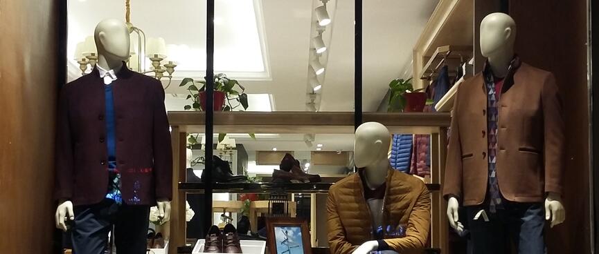 Male manniquens wearing dark-toned blazers and jeans.