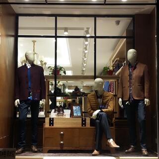 Male manniquens wearing dark-toned blazers and jeans.