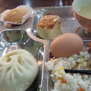 A metal tray with four compartments filled with a variety of foods.