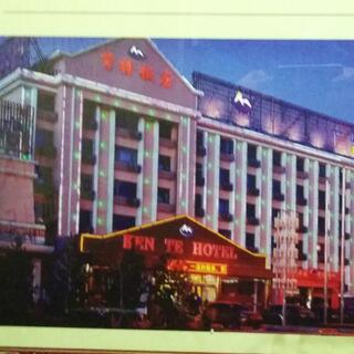 A photograph of a wide six storey building with red neon signage and pale blue strip lighting.