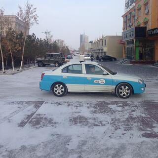 A white taxi with blue trim.