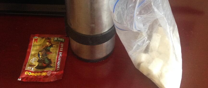 A metal Thermos, tea bag and bag of sugar cubes.