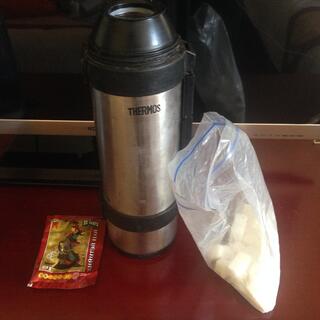 A metal Thermos, tea bag and bag of sugar cubes.