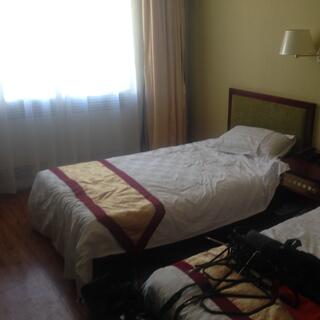 Narrow golden bed throws with red trim.