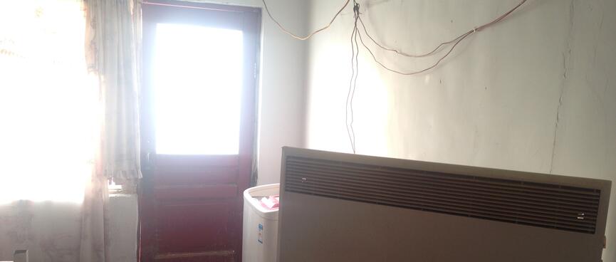 Electrical wiring string across the wall powers a panel heater balancing on a stool.