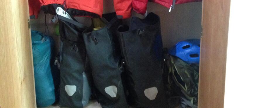 My bike bags and jacketså inside a wardrobe with shelves.