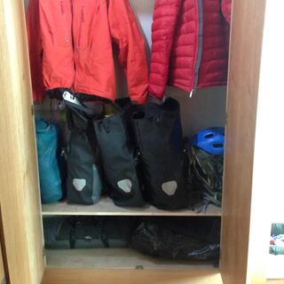 My bike bags and jacketså inside a wardrobe with shelves.