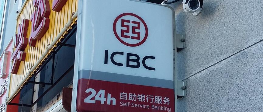 A wall-mounted sign outside the ICBC bank advertises 24 hour self-service banking.