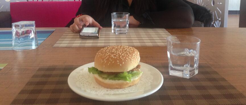Chelmeg sits across from me and a burger on my plate.