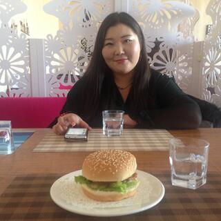 Chelmeg sits across from me and a burger on my plate.