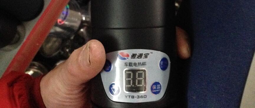 I hold a black YTB-360 electronic flask and a blue neoprene flask sleeve.