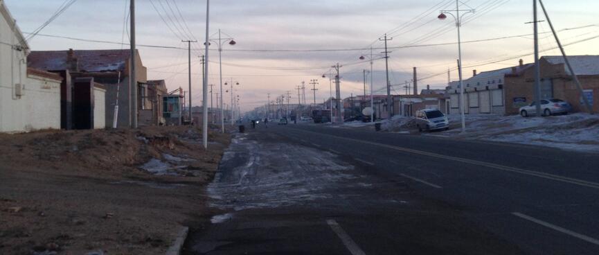 Low rise buildings sit behind undeveloped yards.